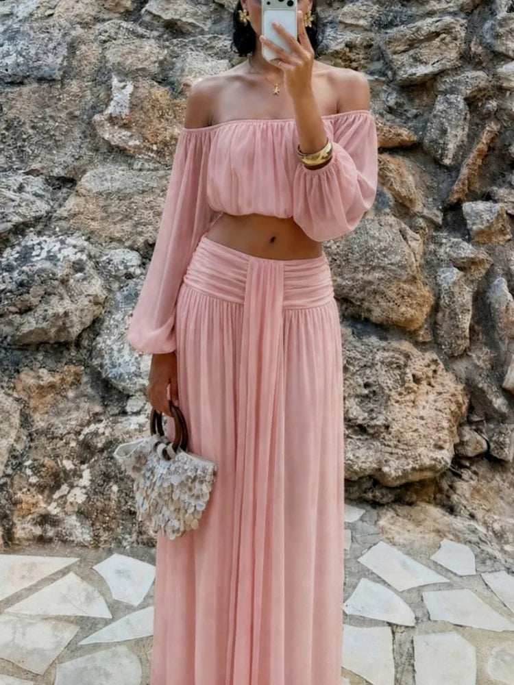 Pink off-shoulder chiffon crop top and maxi skirt with ruched waist detail.