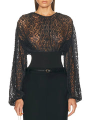 Black lace top worn by a model on a white background