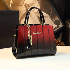 Close-up of a glossy leather satchel handbag, highlighting the gold-tone hardware and luxurious texture. Wine Red 1