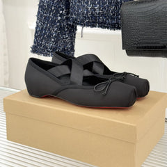 Black ballet flats on a cardboard box with a textured wall and coat in the background