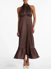Woman wearing a brown polka dot dress on a white background