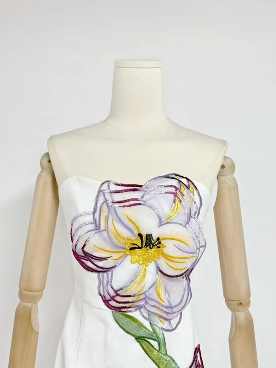 Mannequin wearing a dress with a floral design on a plain background