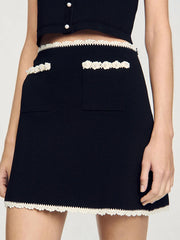 Black skirt with white trim on a plain background