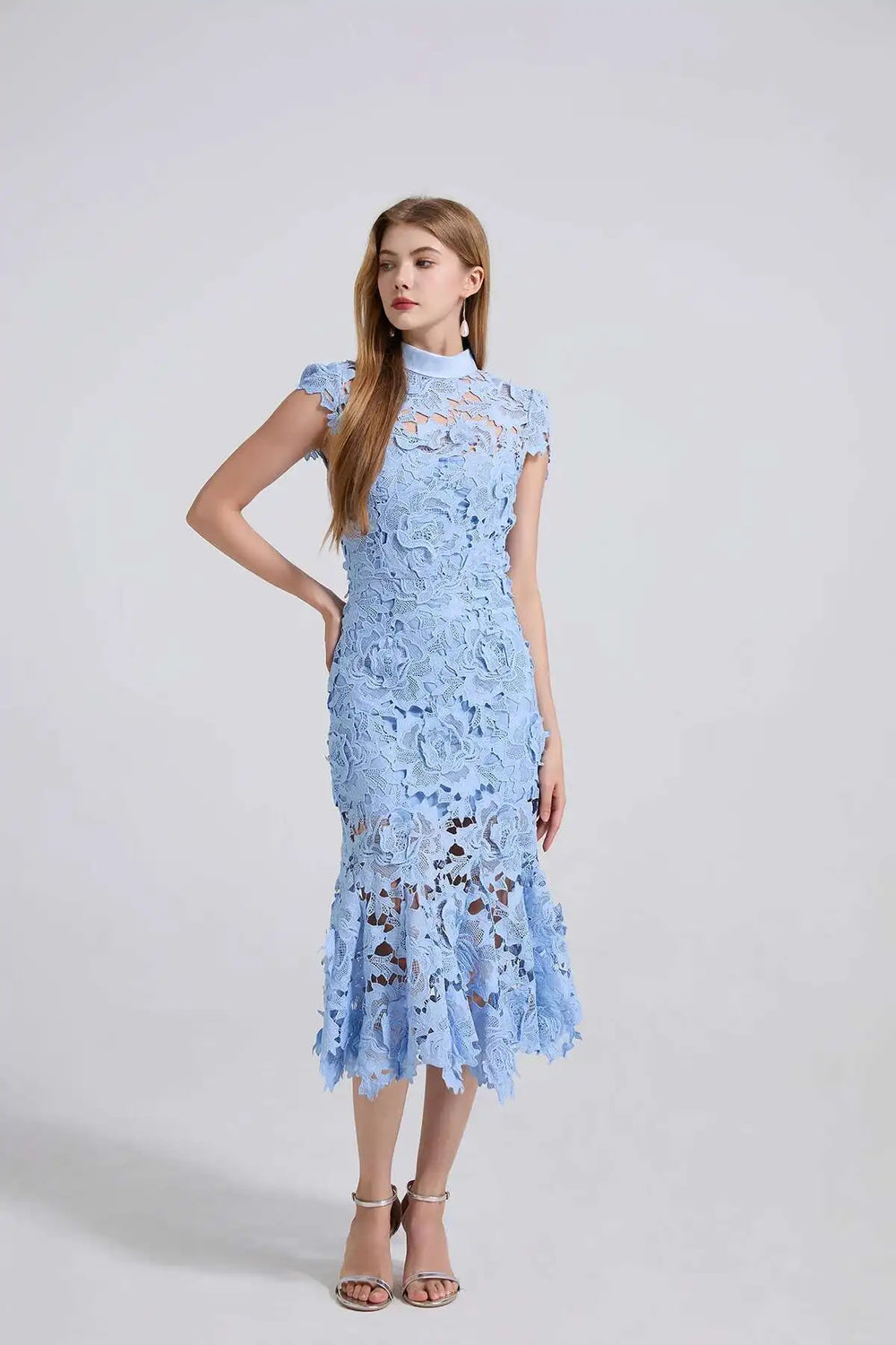 Woman wearing a light blue lace dress on a white background