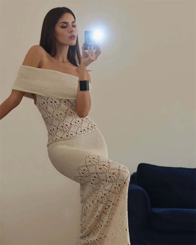 Woman taking a mirror selfie wearing an off-shoulder, patterned dress.