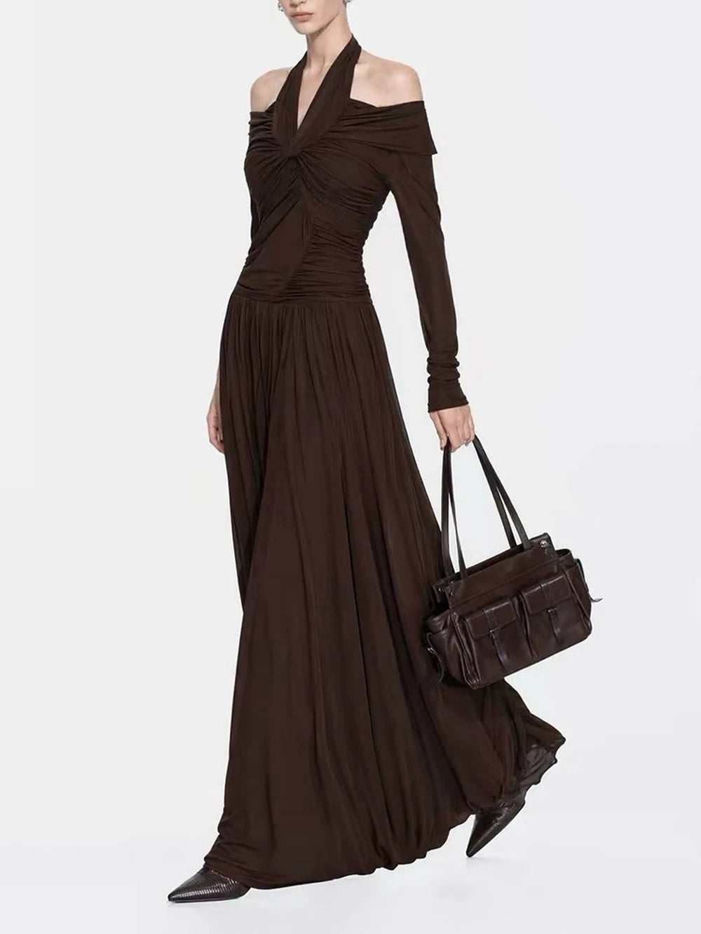 Model wearing ruched halter maxi dress and holding a handbag