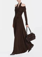 Model wearing ruched halter maxi dress and holding a handbag