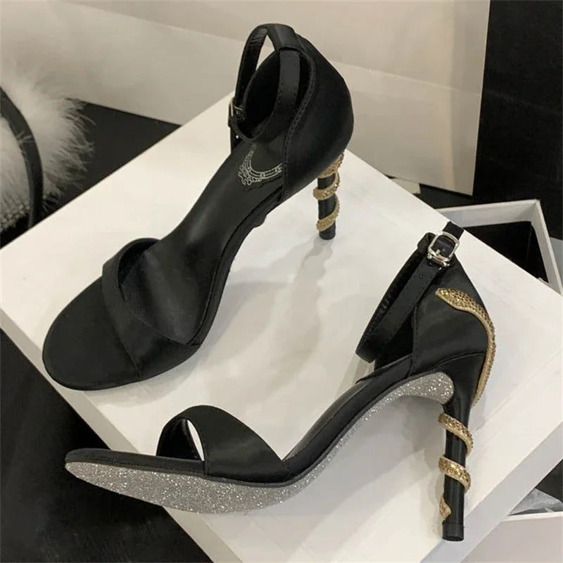 Black high-heeled shoes with glittery accents on a white platform