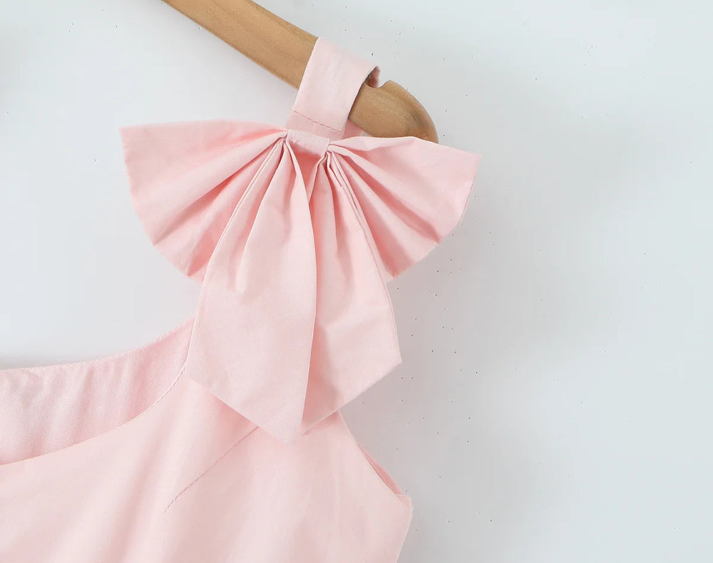 Pink dress with a large bow on a white background