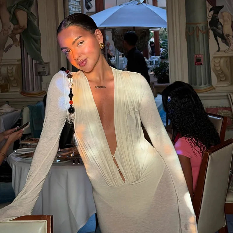 Woman in a white dress with a deep neckline in an indoor setting