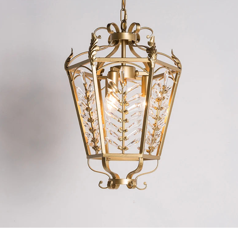 Gold pendant light with intricate design on a gray background