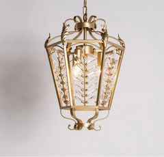 Gold pendant light with intricate design on a gray background