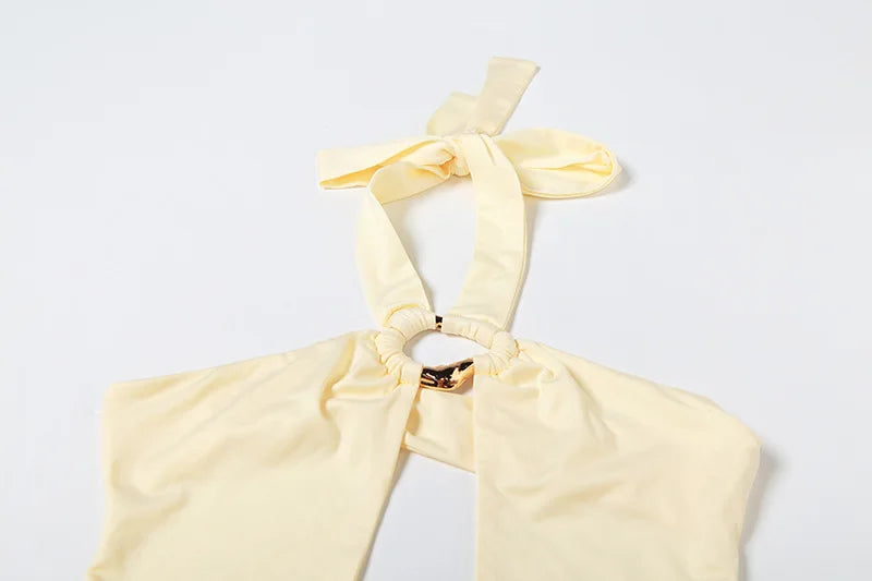 Light yellow halter top with a bow detail on a white background