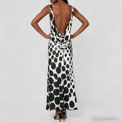 Back view of a dot print sleeveless maxi dress with open cowl back