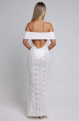Woman wearing a white lace off-shoulder gown on a gray background