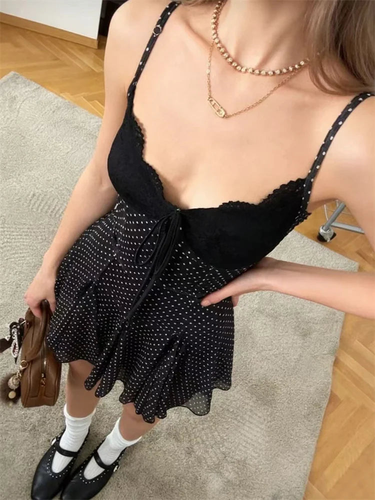 Woman wearing a black dress with white polka dots indoors.