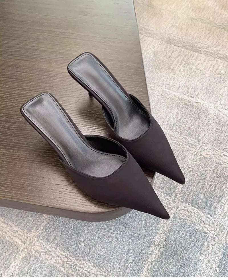 Pair of brown high-heeled shoes on a wooden surface.