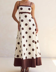 Long polka dot dress with brown accents on a plain background