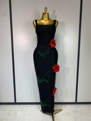 Black body-skimming gown with red floral embellishments and green sparkle detail.