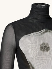 Black turtleneck with sheer overlay and decorative element on a white background