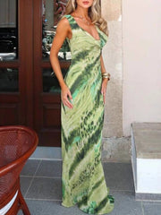 Woman wearing a green patterned dress standing indoors.
