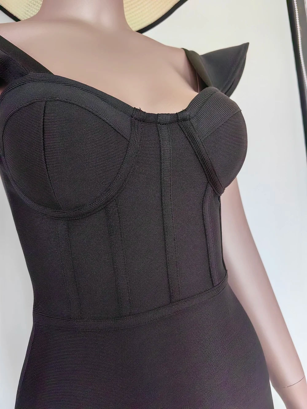 Black dress on a mannequin with a plain background