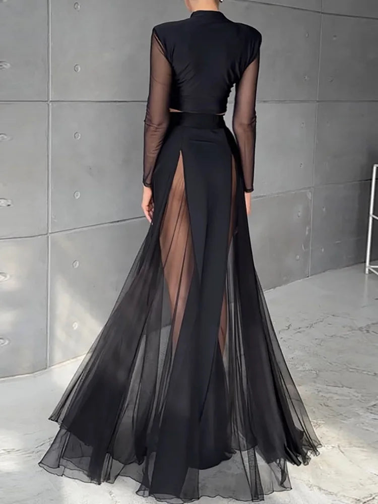 Black sheer dress with a high slit on a gray background