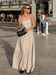Woman in a polka dot dress walking on a street with blurred background