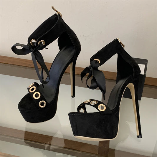 Black platform stiletto lace-up sandals with metal eyelets and ribbon ties.