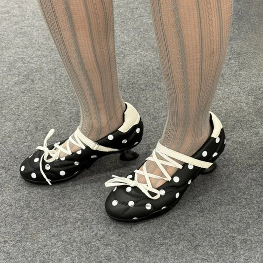 Black polka dot round toe Mary Jane heels with white cross lacing.