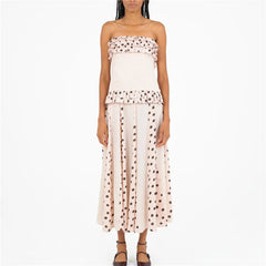 Woman wearing a strapless polka dot dress on a white background