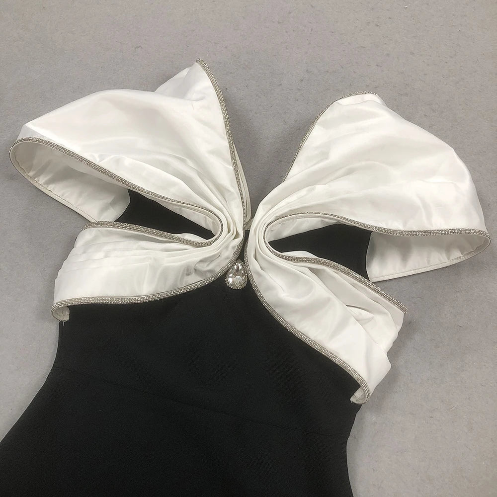 White bow on a black dress against a gray background