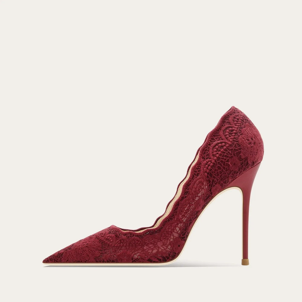 Red lace high-heeled shoe on a light beige background
