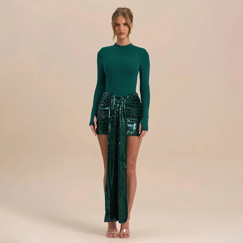 Woman wearing a green long-sleeve top and green sequin skirt on a beige background