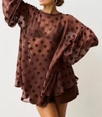 Brown polka dot blouse with sheer sleeves on a white background