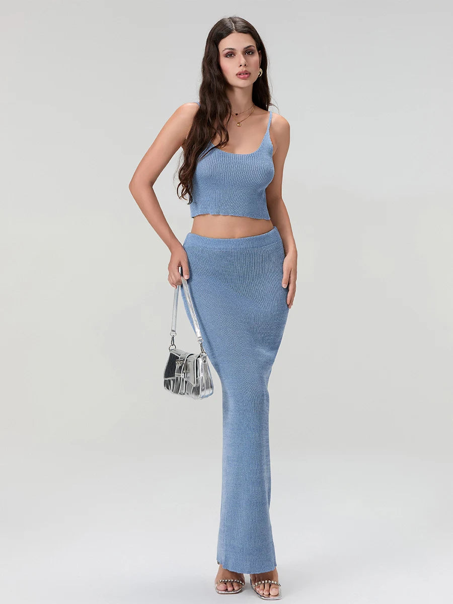 Woman wearing a blue knit outfit holding a silver handbag