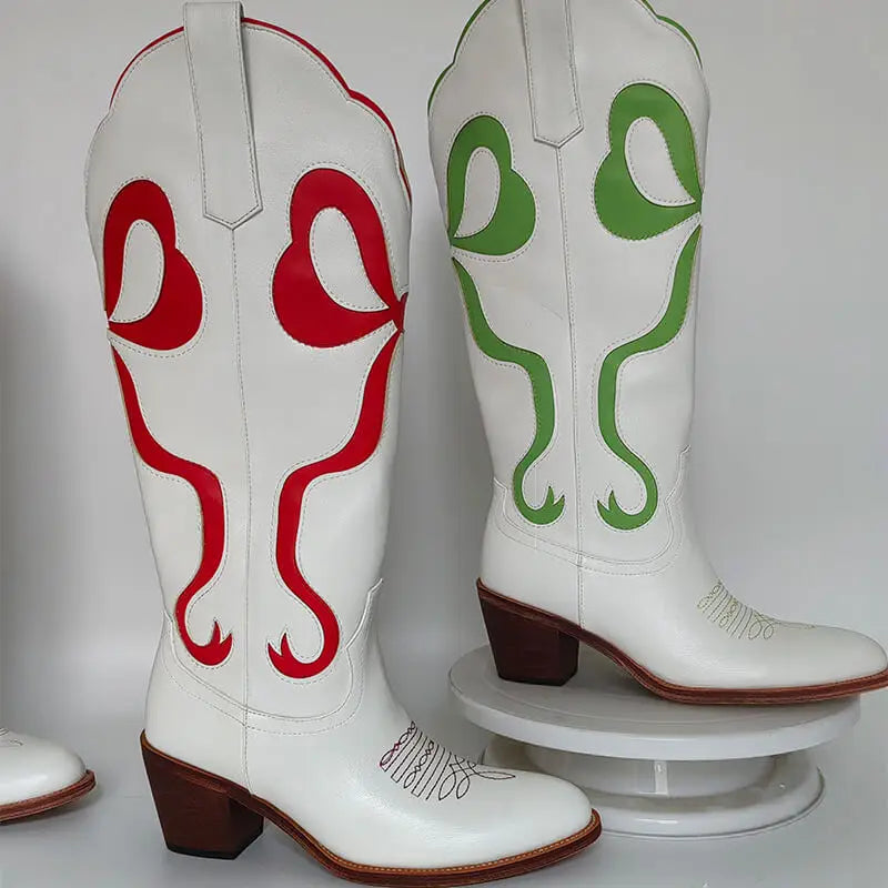 White cowboy boots with red and green designs on a white background