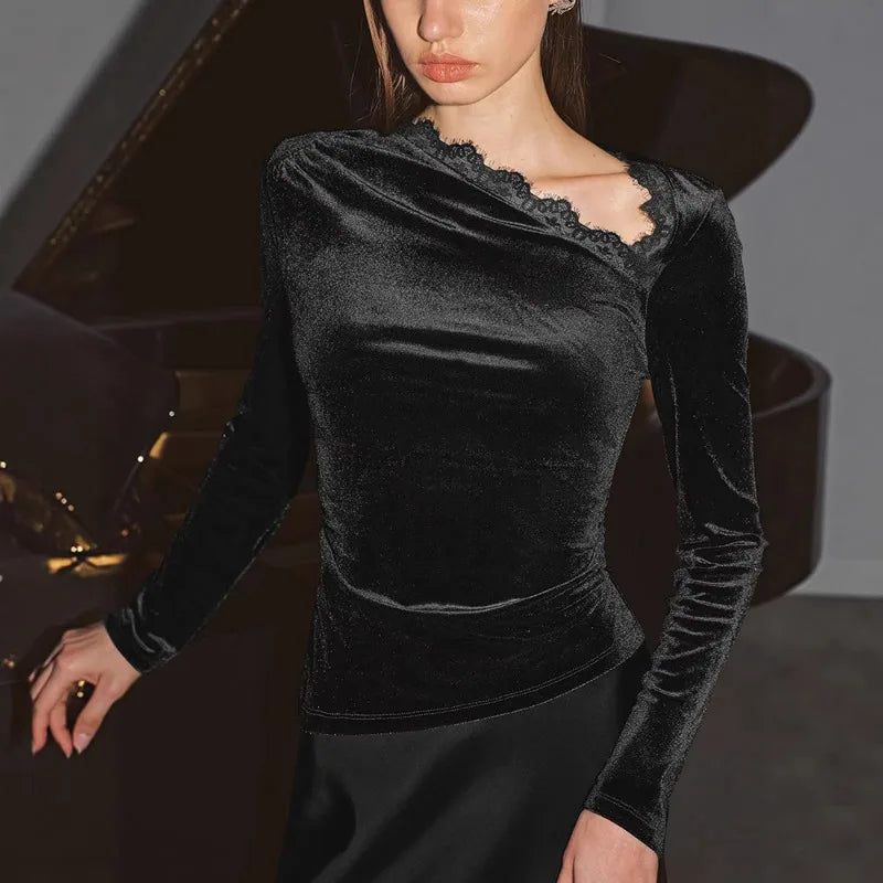 Woman wearing a black velvet top with lace details in a car interior.