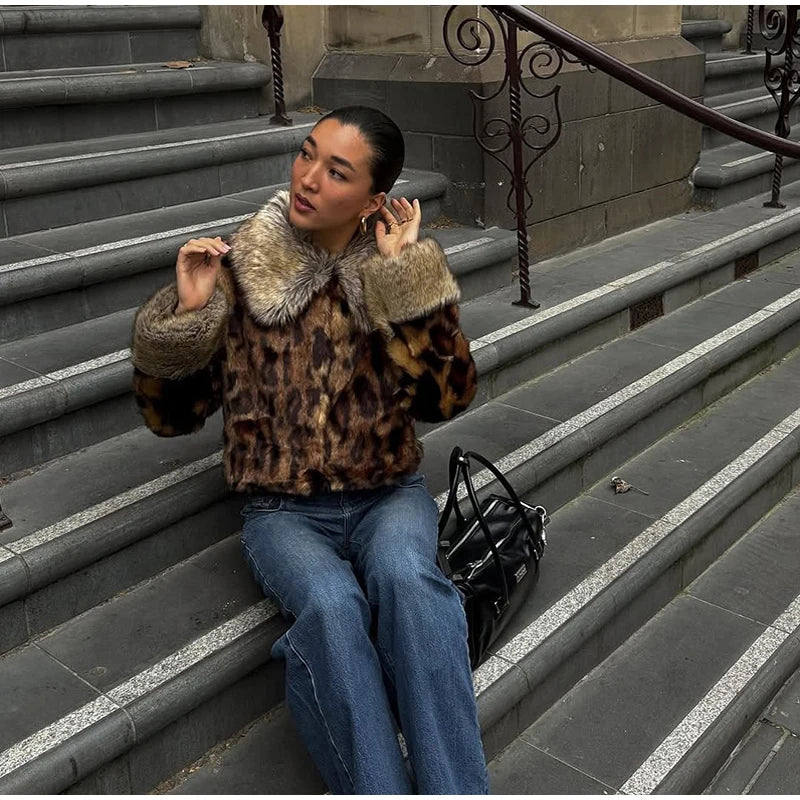 Person wearing a leopard print coat sitting on stone steps.