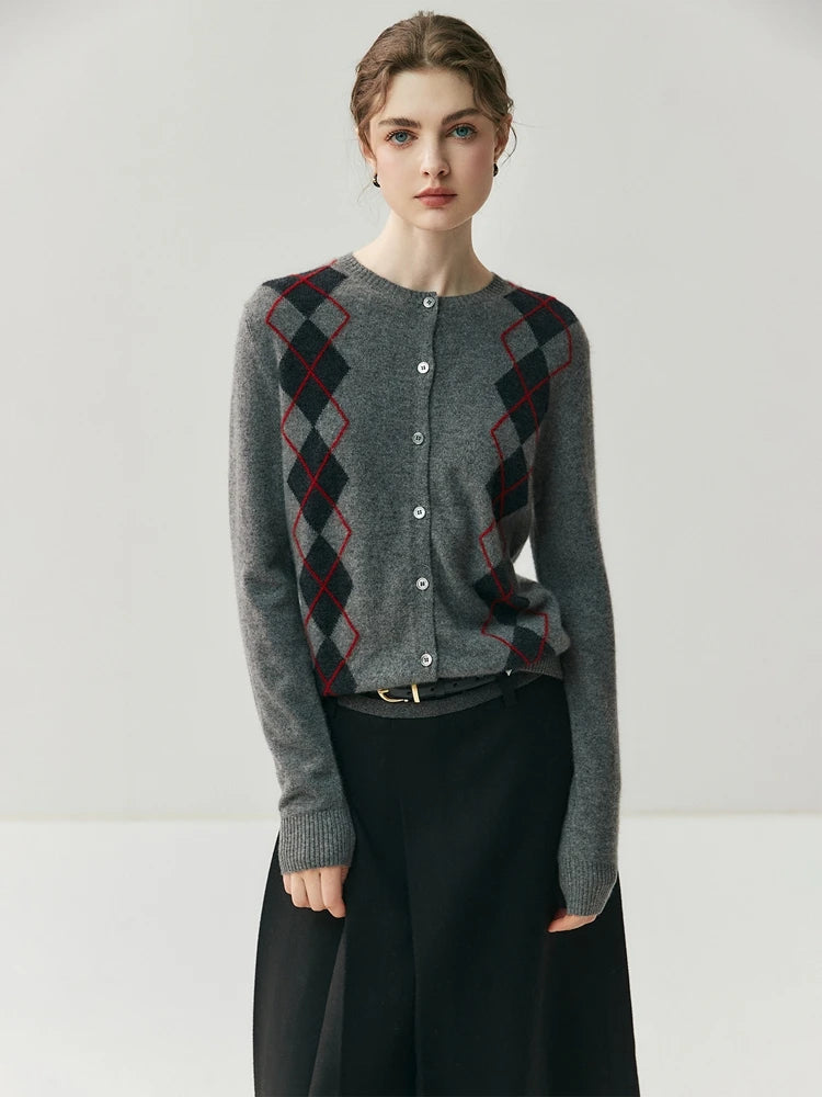 Woman wearing a gray sweater with argyle pattern on a white background