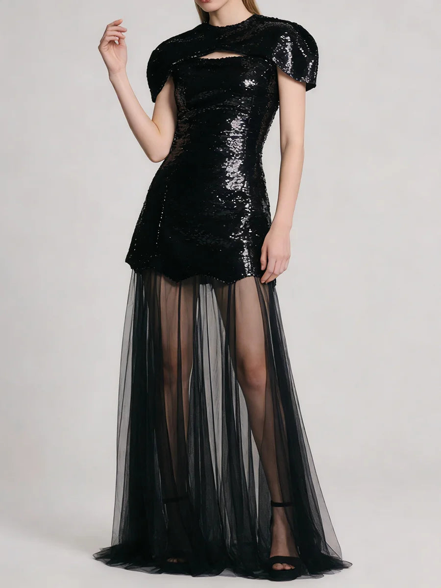 Black sequin mini dress with sheer tulle maxi overlay, model posing with arm raised.