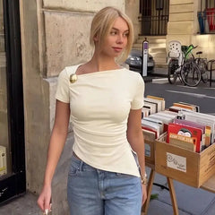 Model outdoors wearing apricot asymmetric neckline top and jeans