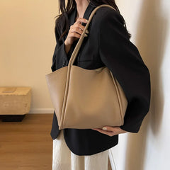 A woman carrying the tote bag on her shoulder, demonstrating its versatility and comfortable fit for everyday use.