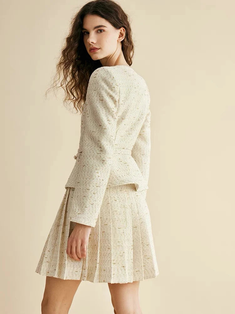 Woman wearing a light-colored suit with a skirt on a beige background