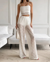 Woman wearing a white lace outfit in a minimalistic room.