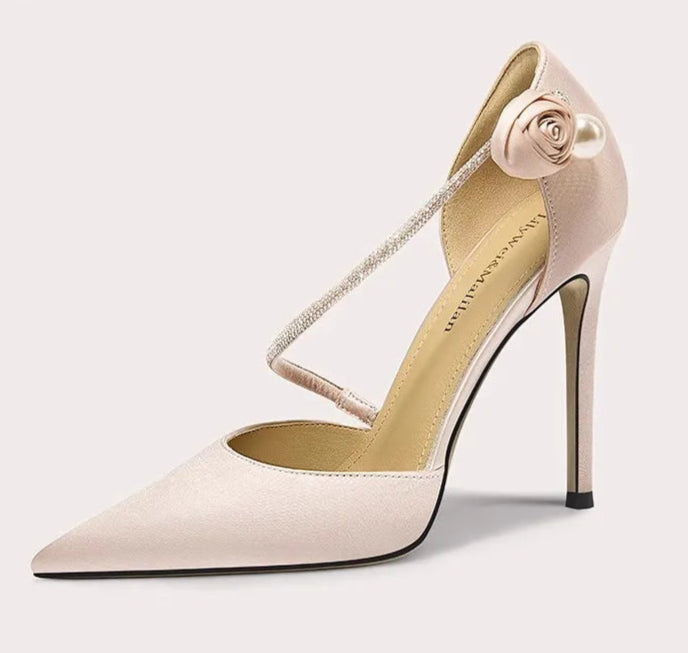 High-heeled shoe with a decorative strap on a light gray background