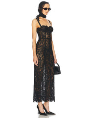 Woman wearing a black lace dress with sunglasses and a handbag on a white background