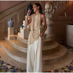 Model wearing a draped halter neck sleeveless top with wide-leg pants