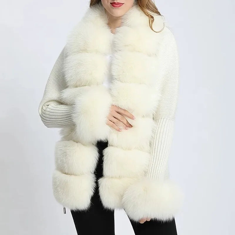 Woman wearing a long, white fur vest over a gray sweater