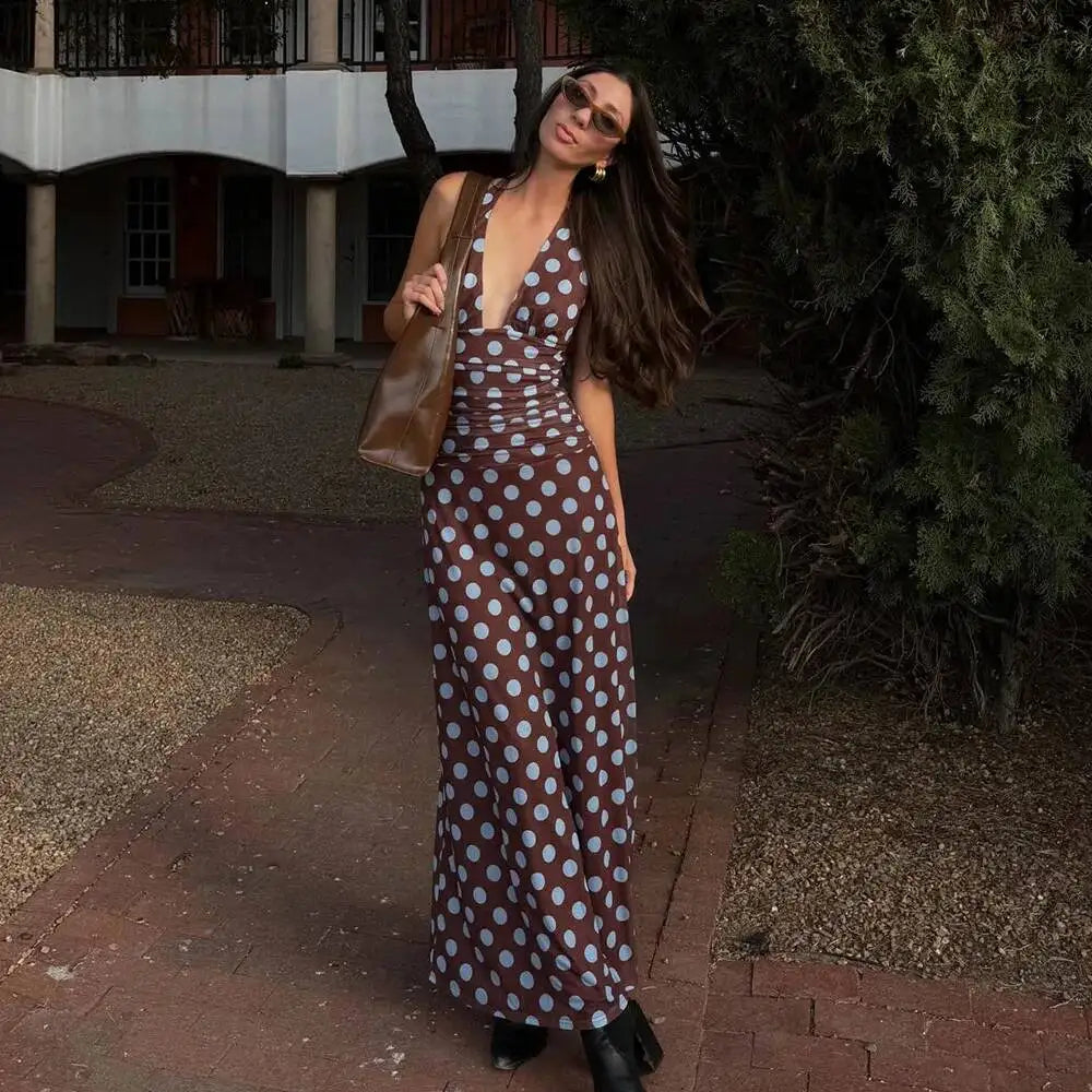 Model posing in a polka dot deep v neck halter maxi dress outdoors